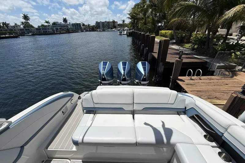 Slide: The Image of 2025 Formula 330 Crossover Bowrider OB with triple engines docked by palm trees. - 17