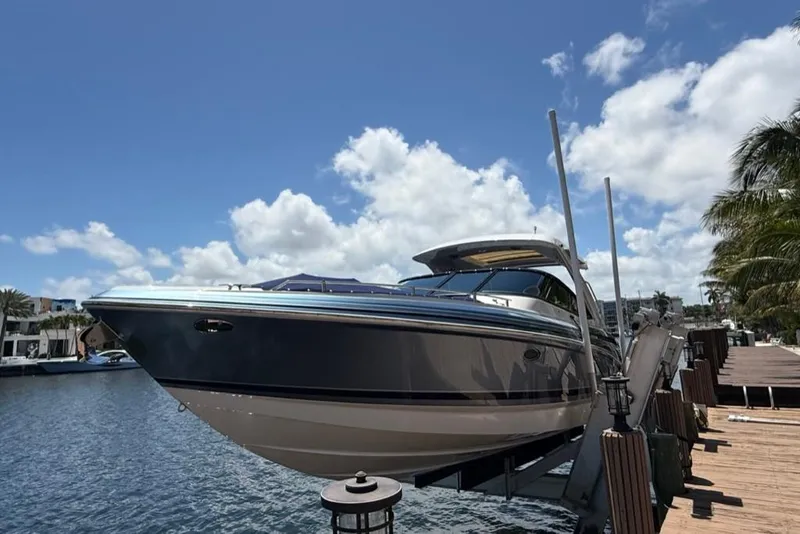 Slide: The Image of 2025 Formula 330 Crossover Bowrider OB on dock, sunny day, palm trees nearby. - 4