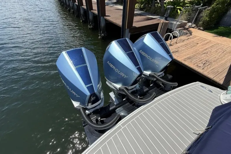 Slide: The Image of 2025 Formula 330 Crossover Bowrider OB with twin Mercury outboard engines docked by water. - 5