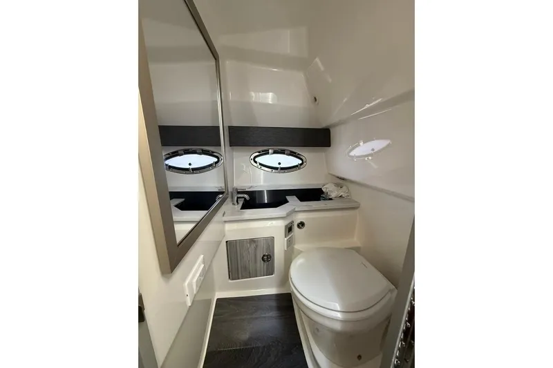 Slide: The Image of 2025 Formula 330 Crossover Bowrider OB bathroom with modern fixtures and porthole windows. - 51