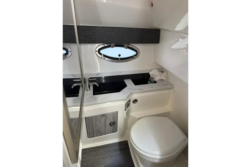 Slide: The Image of 2025 Formula 330 Crossover Bowrider OB bathroom with modern fixtures and porthole window. - 52