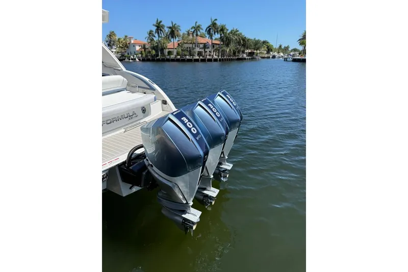 Slide: The Image of 2025 Formula 330 Crossover Bowrider OB with triple outboard engines on a sunny waterfront. - 6