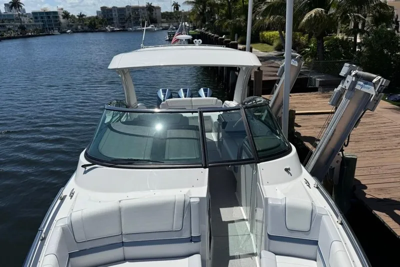 Slide: The Image of 2025 Formula 330 Crossover Bowrider OB docked by a scenic waterfront. - 64