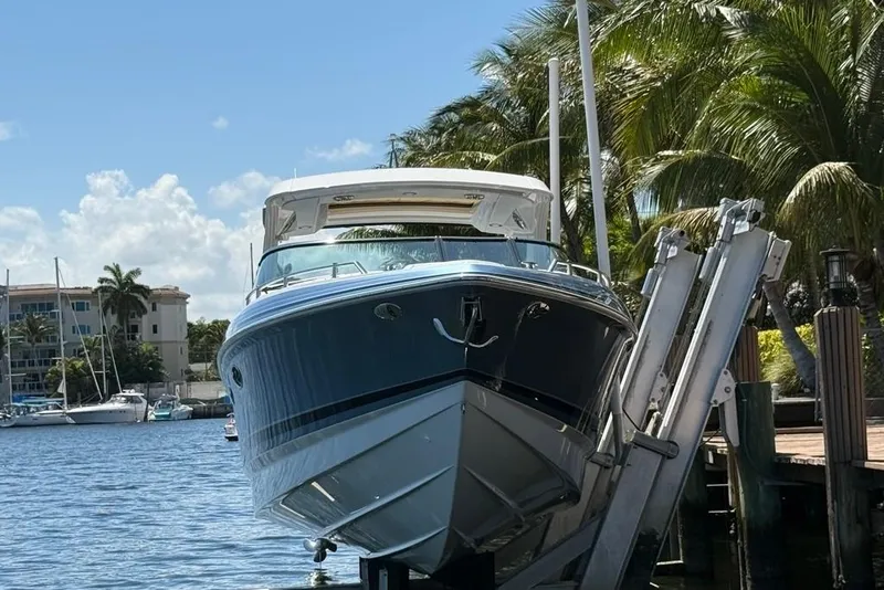 Slide: The Image of 2025 Formula 330 Crossover Bowrider OB docked by palm trees and waterfront. - 67