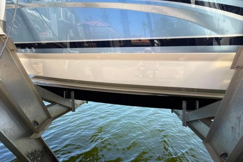 Slide: The Image of 2025 Formula 330 Crossover Bowrider OB on a boat lift over water. - 68
