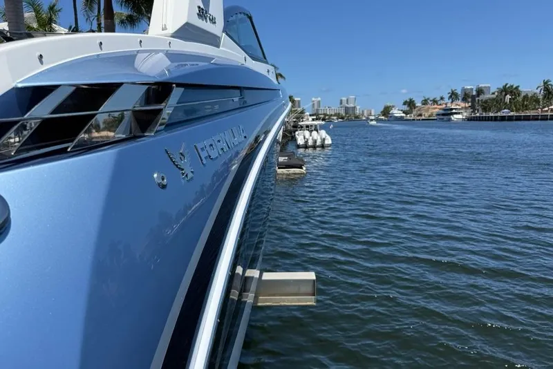 Slide: The Image of 2025 Formula 330 Crossover Bowrider OB docked on a sunny waterfront. - 7
