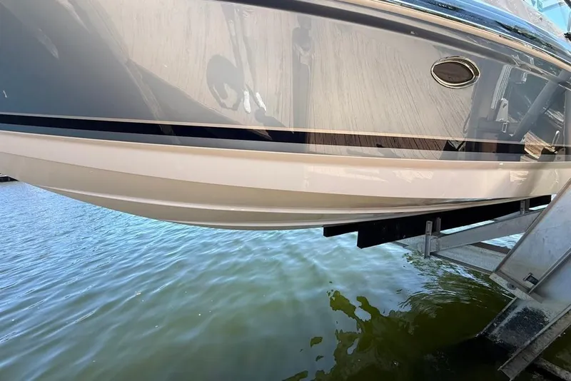 Slide: The Image of 2025 Formula 330 Crossover Bowrider OB on lift above water. - 70