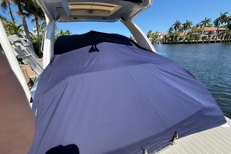 Slide: The Image of 2025 Formula 330 Crossover Bowrider OB covered, docked by palm-lined waterfront. - 71