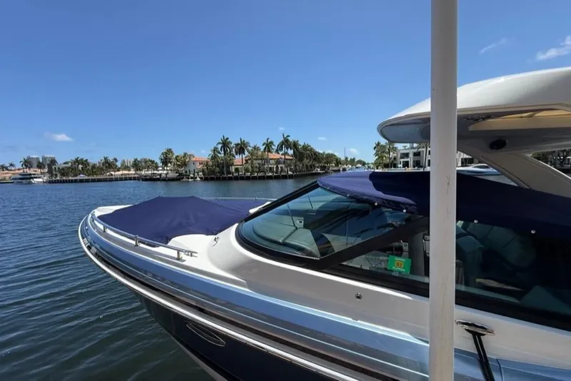 Slide: The Image of 2025 Formula 330 Crossover Bowrider OB on a sunny waterfront, showcasing sleek design. - 76