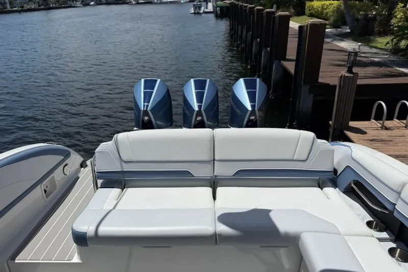 Slide: The Image of 2025 Formula 330 Crossover Bowrider OB with triple outboard engines, docked by a serene waterfront. - 8