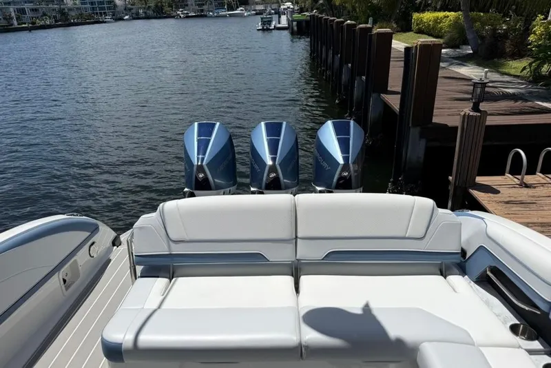 Slide: The Image of 2025 Formula 330 Crossover Bowrider OB with triple outboard engines docked by the water. - 9