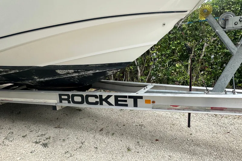 Slide: The Image of 2004 Boston Whaler 270 Outrage on Rocket trailer, parked on gravel. - 11