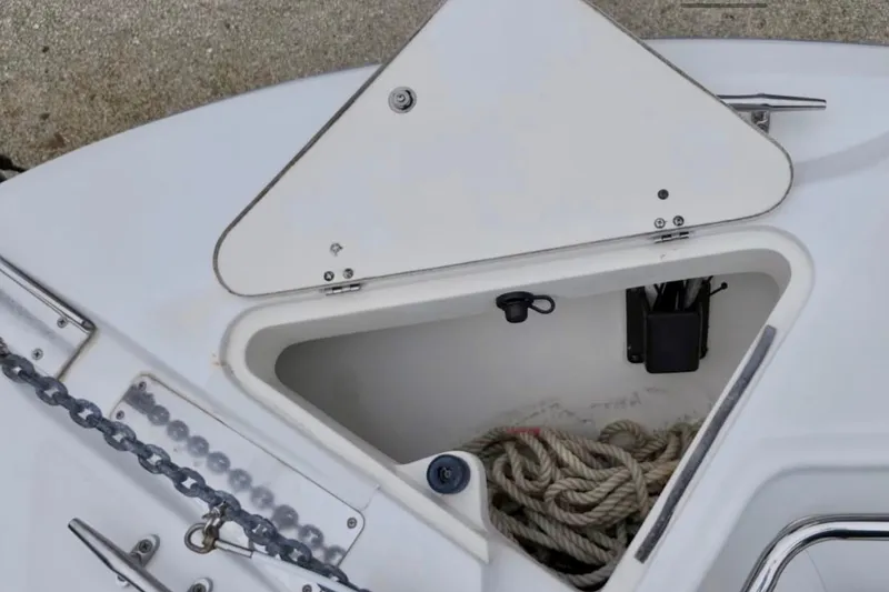Slide: The Image of Open storage compartment on a 2004 Boston Whaler 270 Outrage boat with rope and chain. - 19