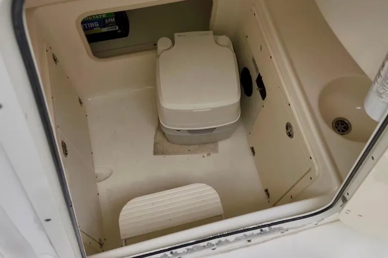 Slide: The Image of 2004 Boston Whaler 270 Outrage boat interior with portable toilet and sink. - 23