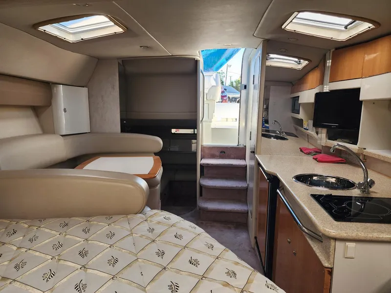 Slide: The Image of Interior of a 2002 Formula 31 PC boat, featuring a cozy cabin and kitchenette. - 6