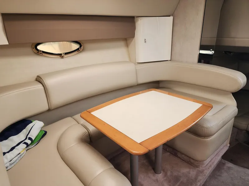 Slide: The Image of 2002 Formula 31 PC cabin interior with beige seating and wooden table. - 7