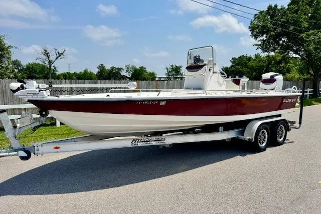 The Image of 2003 Blazer Bay 2220 Fisherman boat on trailer, parked on a sunny street. - 1