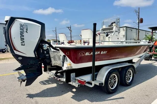 Slide: The Image of 2003 Blazer Bay 2220 Fisherman boat on trailer with Evinrude engine, parked outdoors. - 4