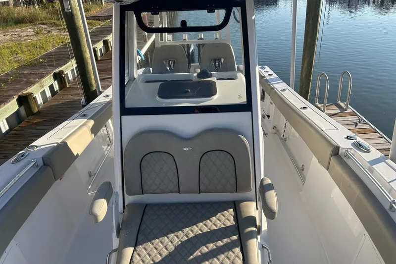 Slide: The Image of 2022 Sportsman Open 282TE Center Console boat docked by the water. - 2
