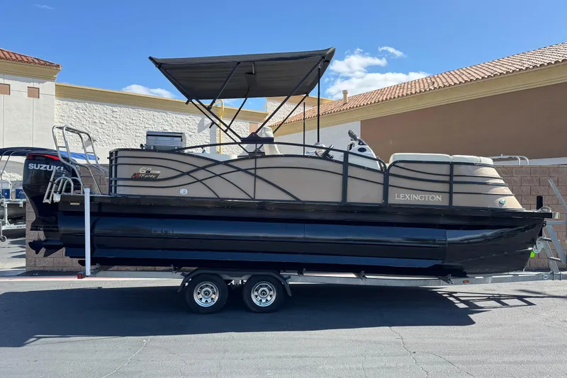 The Image of 2023 Lexington 623 ST Xtreme pontoon boat on trailer, featuring a Suzuki outboard motor. - 0