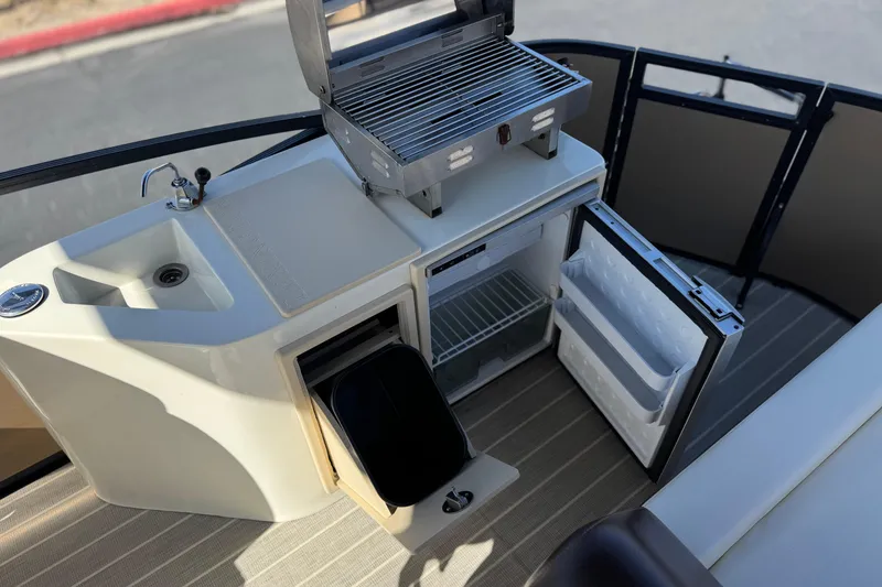 Slide: The Image of 2023 Lexington 623 ST Xtreme boat kitchen with grill, sink, and mini fridge. - 19