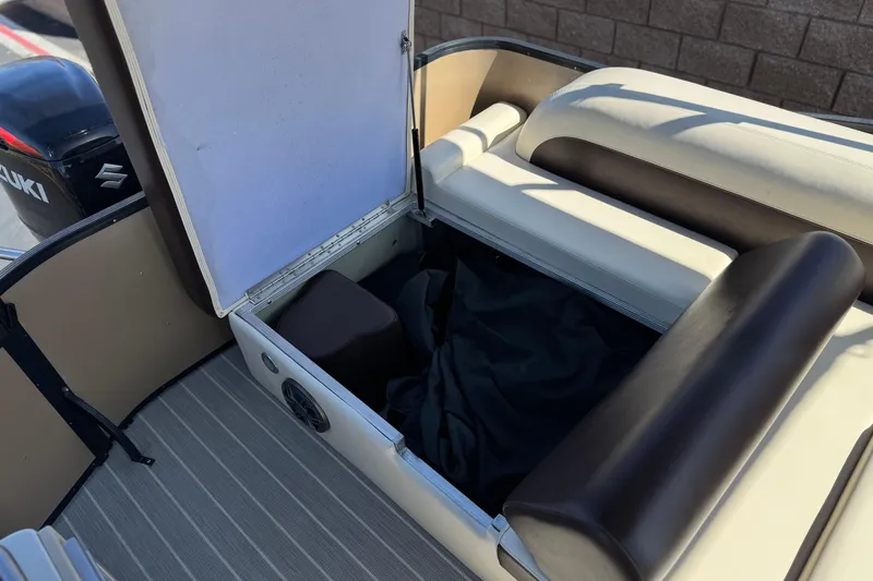 Slide: The Image of 2023 Lexington 623 ST Xtreme boat storage compartment with open seat and Suzuki engine. - 24