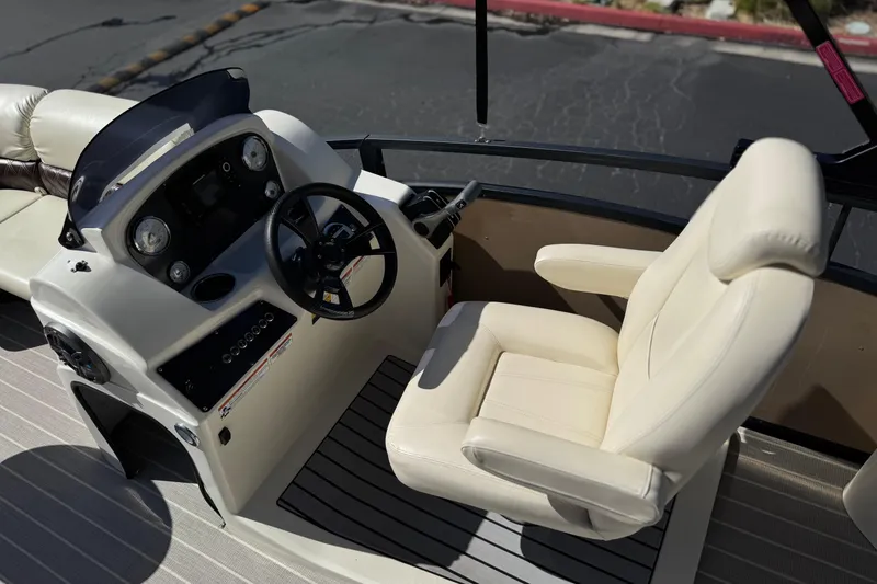 Slide: The Image of 2023 Lexington 623 ST Xtreme boat cockpit with steering wheel and plush captain's chair. - 25