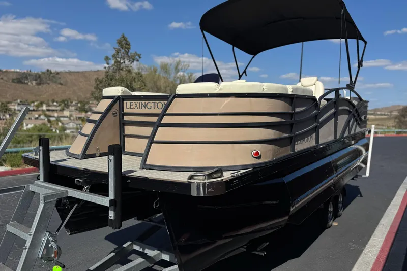 Slide: The Image of 2023 Lexington 623 ST Xtreme pontoon boat on trailer, parked outdoors. - 3