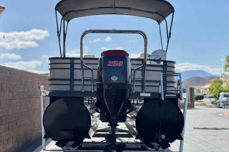 Slide: The Image of 2023 Lexington 623 ST Xtreme pontoon boat with powerful 250 HP engine, parked outdoors. - 5