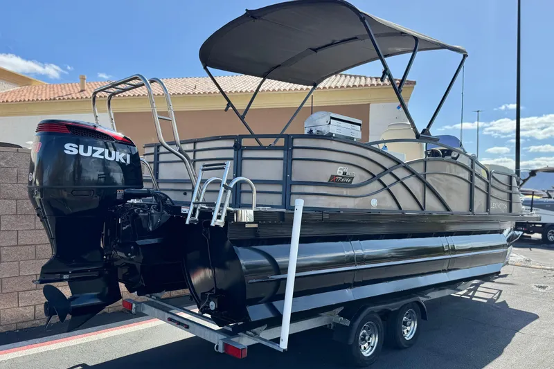 Slide: The Image of 2023 Lexington 623 ST Xtreme pontoon boat with Suzuki outboard motor on trailer. - 6