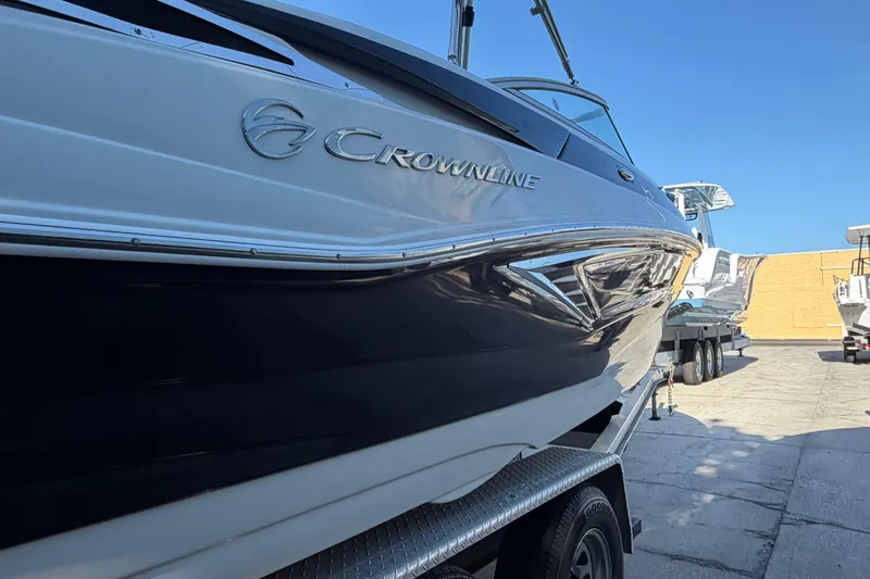 Slide: The Image of 2019 Crownline Eclipse E215 XS boat on trailer under clear blue sky. - 2