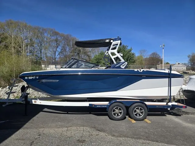 The Image of 2021 Nautique Super Air Nautique G23 on trailer, blue and white design. - 1