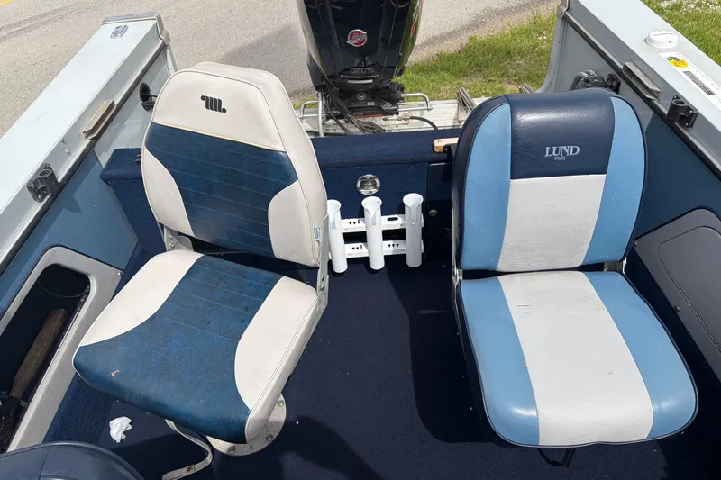 Slide: The Image of Interior of a 1991 Lund 1750 Tyee boat with two blue and white seats. - 13