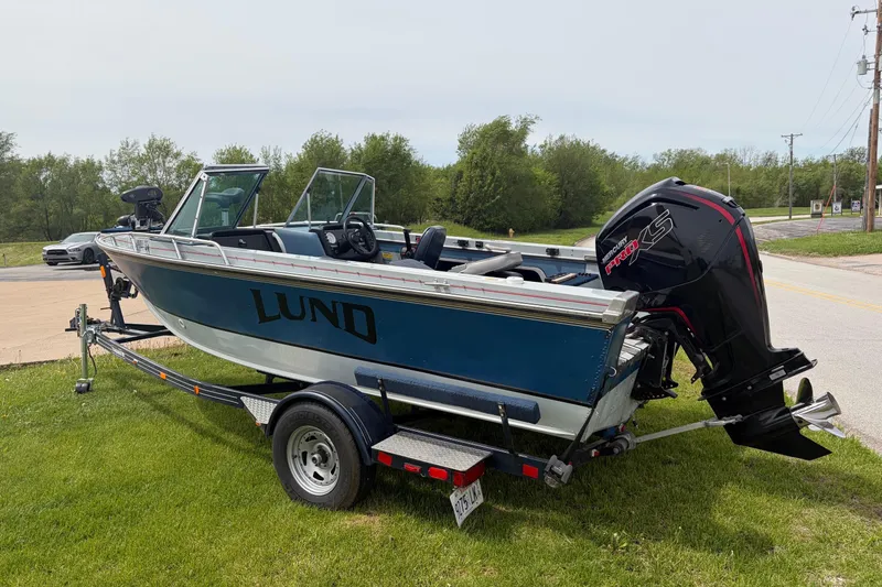 Slide: The Image of 1991 Lund 1750 Tyee boat on trailer with Mercury Pro XS engine, parked on grass. - 7