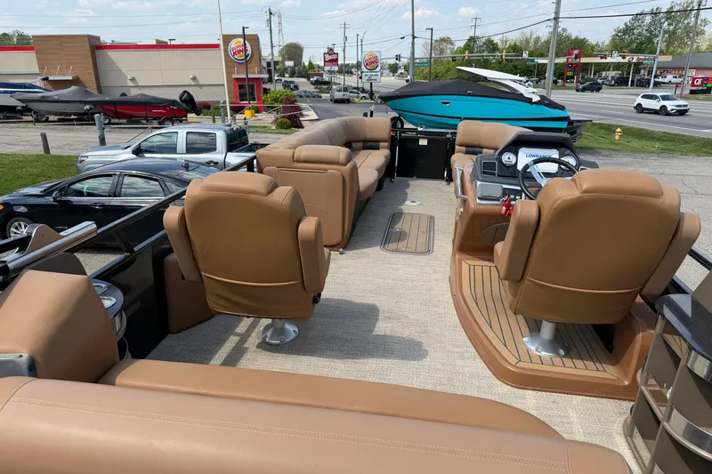 Slide: The Image of 2020 Regency 250 LE3 Sport boat interior with tan seating and dashboard controls. - 9