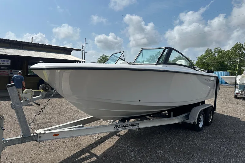 The Image of 2024 Aquasport 2200 Dual Console boat on trailer under cloudy sky. - 0