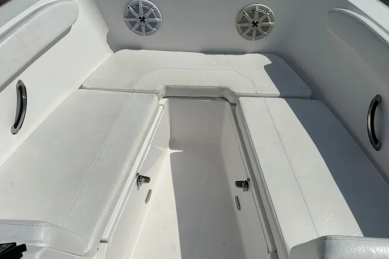 Slide: The Image of 2024 Aquasport 2200 Dual Console boat interior with cushioned seating and speakers. - 11