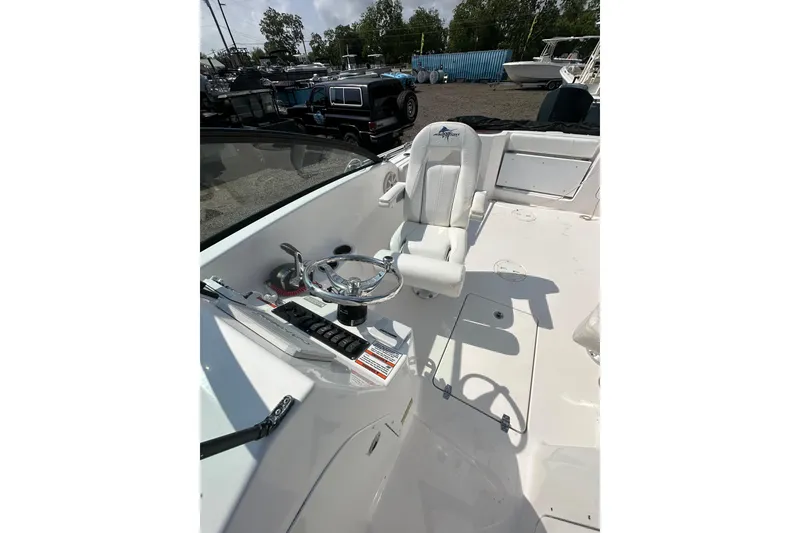 Slide: The Image of 2024 Aquasport 2200 Dual Console boat interior with steering wheel and captain's chair. - 17