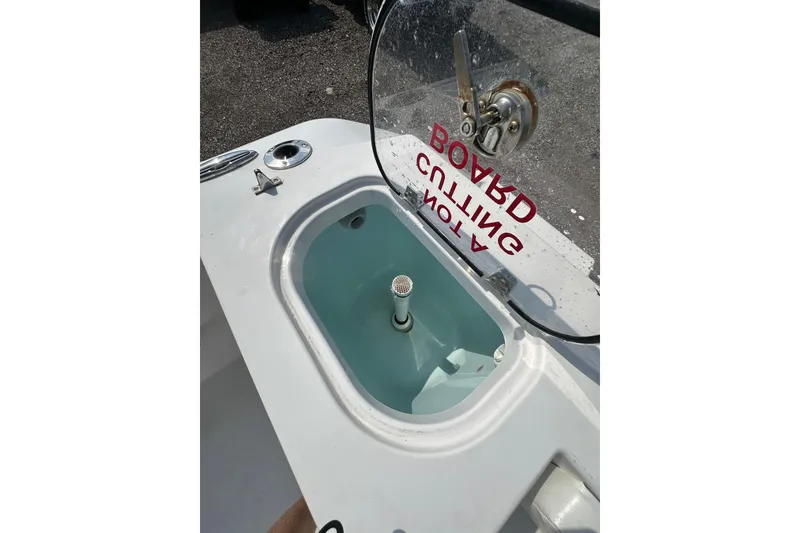 Slide: The Image of 2024 Aquasport 2200 Dual Console boat livewell with open lid and visible fittings. - 22