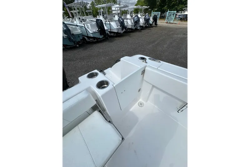 Slide: The Image of 2024 Aquasport 2200 Dual Console boat interior with cup holders and seating. - 23