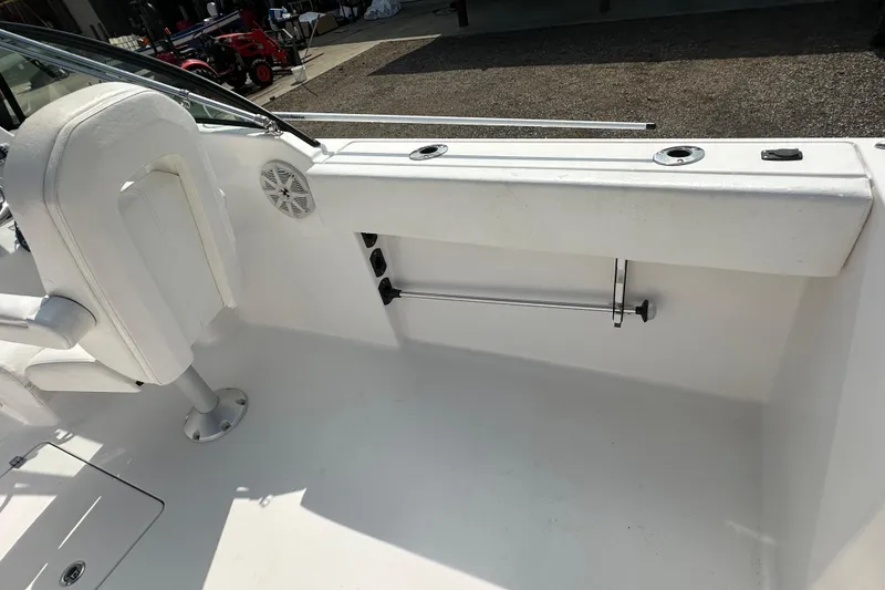 Slide: The Image of 2024 Aquasport 2200 Dual Console interior with white seating and rod holders. - 25
