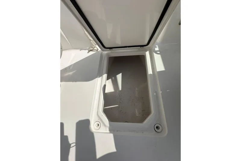 Slide: The Image of Open storage compartment on 2024 Aquasport 2200 Dual Console boat. - 27
