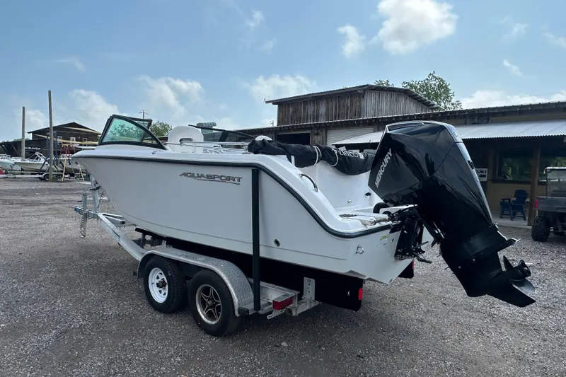 Slide: The Image of 2024 Aquasport 2200 Dual Console boat on trailer with Mercury outboard motor. - 3