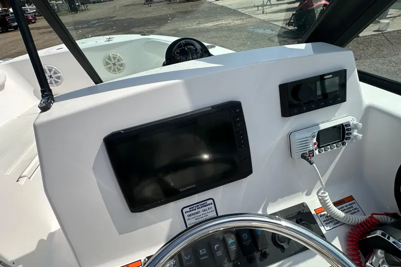 Slide: The Image of 2024 Aquasport 2200 Dual Console dashboard with Garmin display and marine radio. - 30