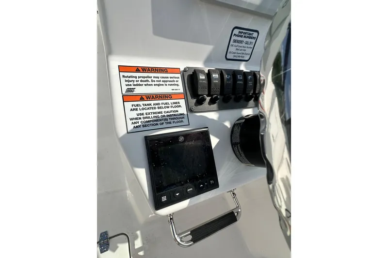 Slide: The Image of Control panel of 2024 Aquasport 2200 Dual Console with warning labels and switches. - 31