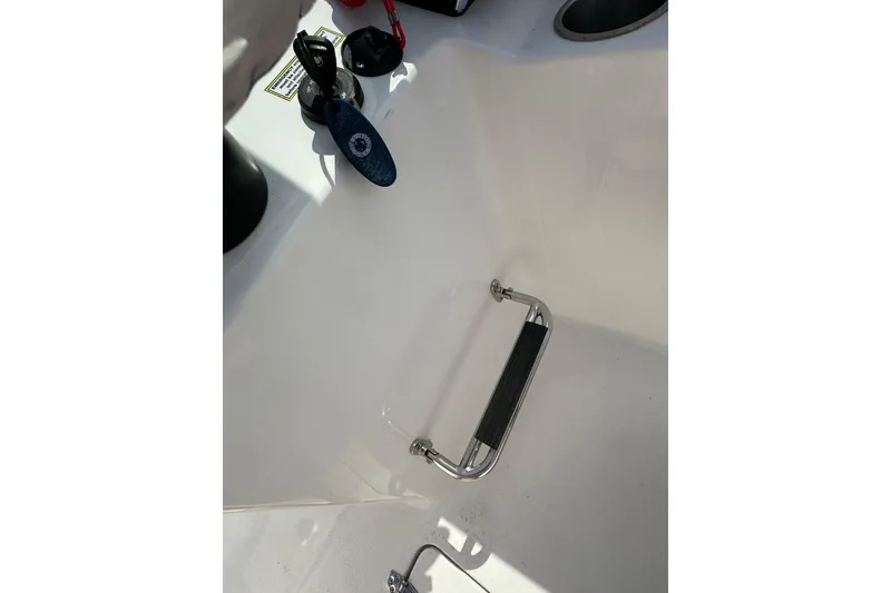 Slide: The Image of 2024 Aquasport 2200 Dual Console boat interior with grab handle and ignition key. - 32