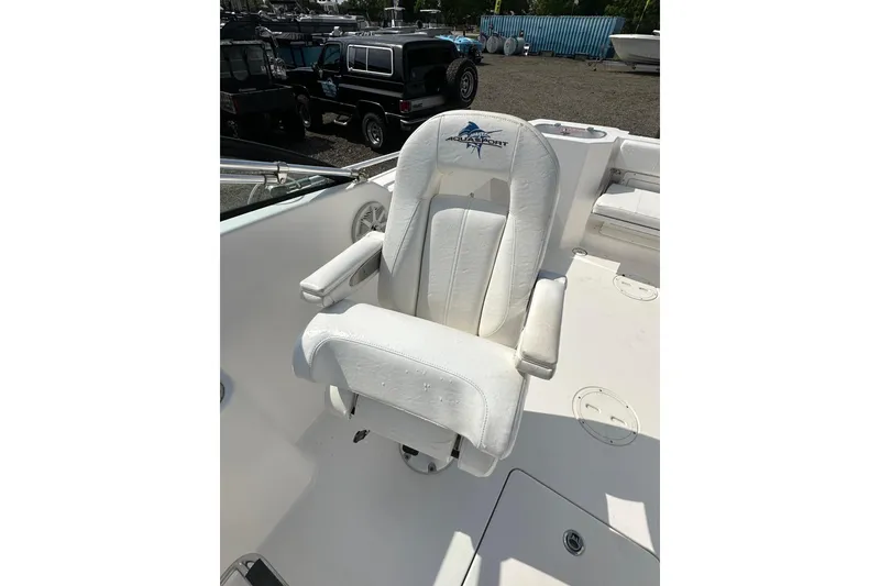 Slide: The Image of 2024 Aquasport 2200 Dual Console boat seat with logo, in a sunny outdoor setting. - 34