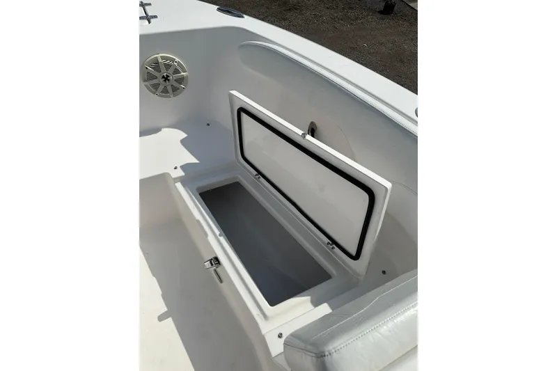 Slide: The Image of 2024 Aquasport 2200 Dual Console boat storage compartment with open lid and speaker. - 38