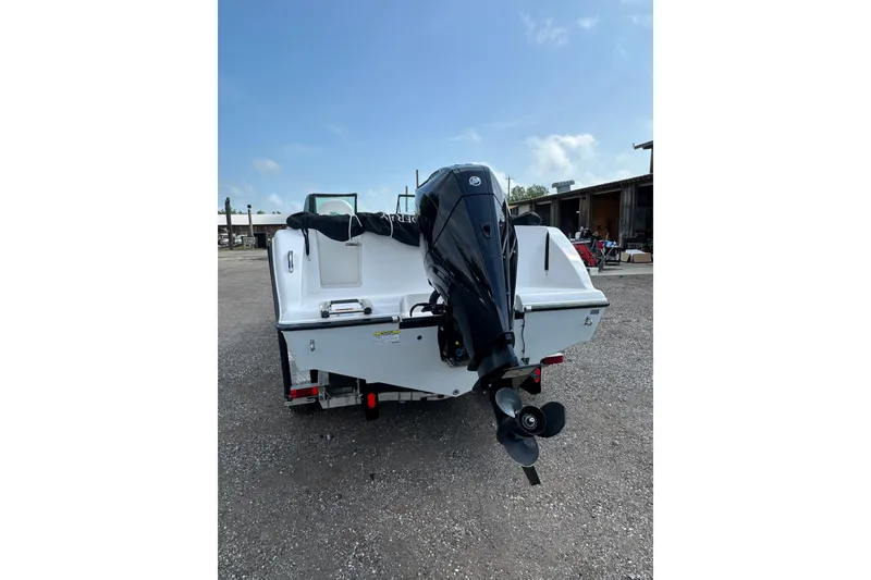 Slide: The Image of 2024 Aquasport 2200 Dual Console boat with outboard motor, parked on gravel. - 4