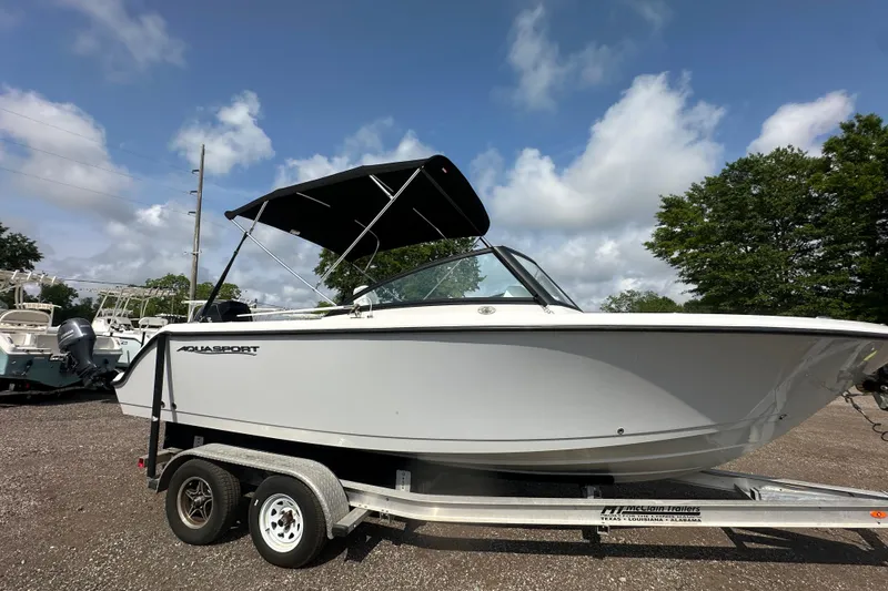 Slide: The Image of 2024 Aquasport 2200 Dual Console boat on trailer under blue sky. - 43